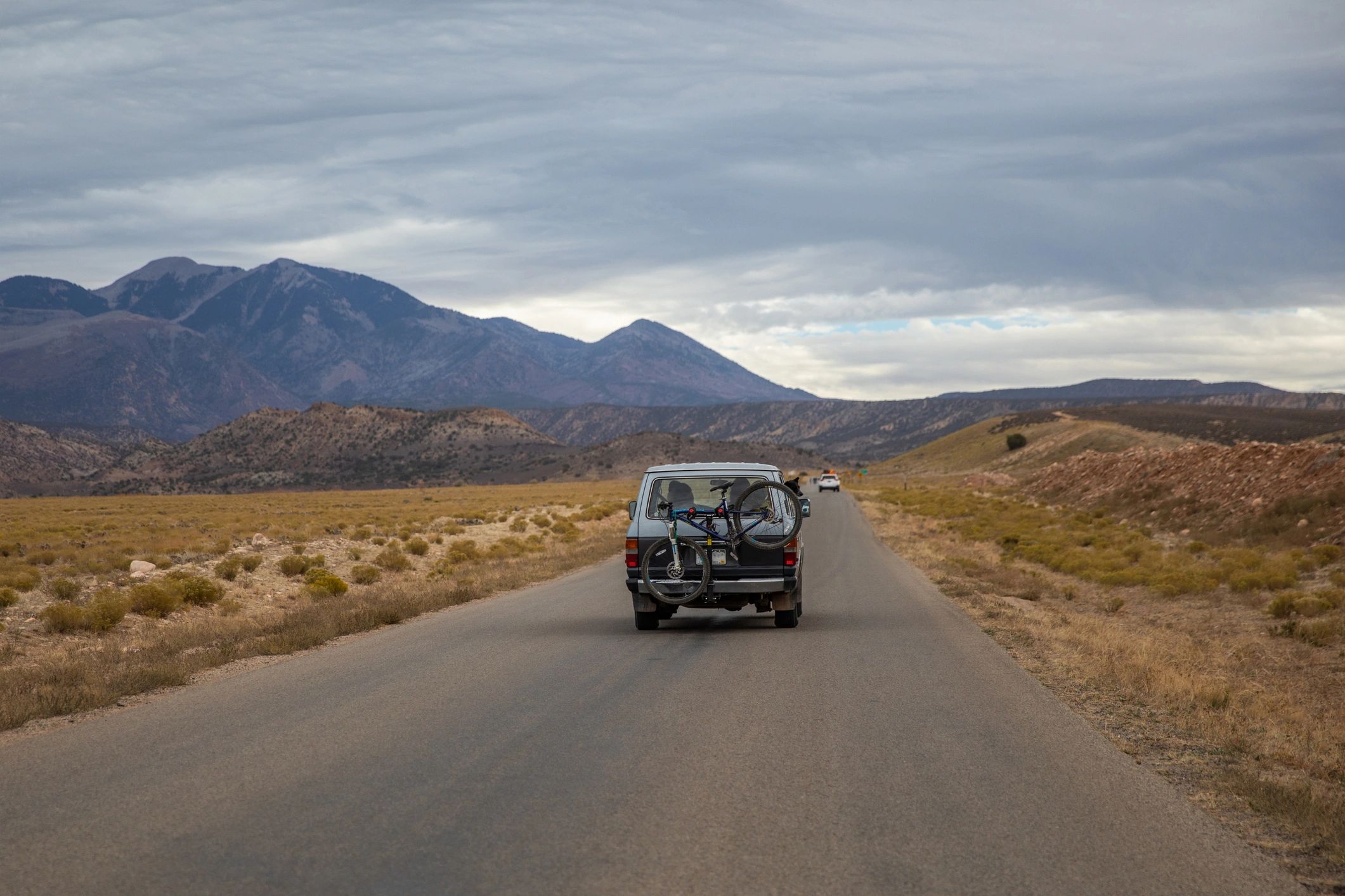 Sports utility vehicle driving toward distant mountains on an adventure route