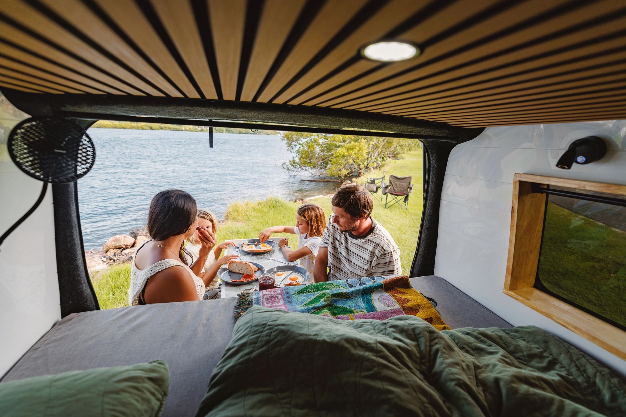 Happy campers enjoying an outdoor breakfast by the lake