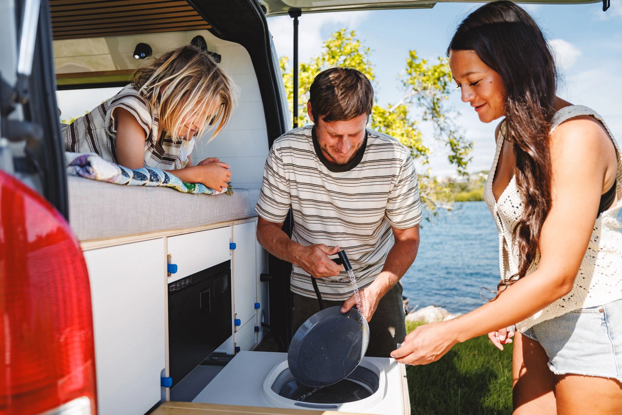 Family preparing breakfast outdoors while camping