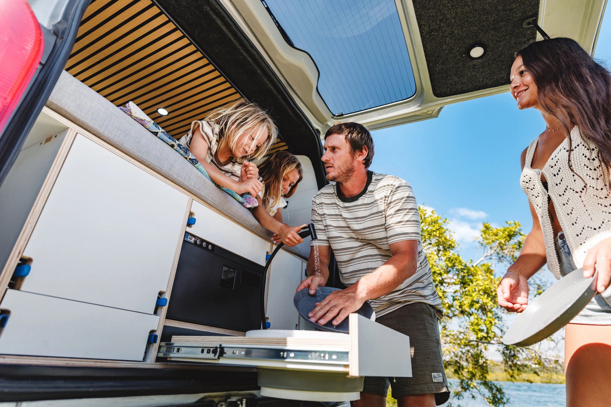 Family enjoying the lifestyle around a modern camper